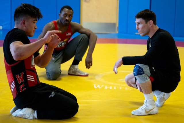 Spc. Spencer Woods, left,  a Army World Class Athlete Program Soldier-athlete,  discusses technique with Sgt. Ildar Hafizov, right, and Spc. Timothy Young, middle, at Fort Carson, Colo. on March 12, 2024. (DoD photo by EJ Hersom)