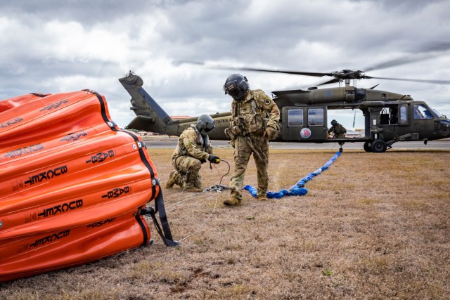 U.S. Soldiers assigned to the 1st Battalion, 183rd Aviation Regiment, the 1st Battalion, 189th Aviation Regiment and 3rd Battalion, 126th Aviation Regiment, Hawaii Army National Guard, secure a Bambi bucket to a UH-60M Black Hawk helicopter during aerial fire suppression water drop operations in response to the Mililani wildfires at Mililani, Hawaii, Nov. 4, 2023. The Hawaii National Guard has conducted over 70 water drops and 30,000 gallons of water over the wildfires in Mililani.
