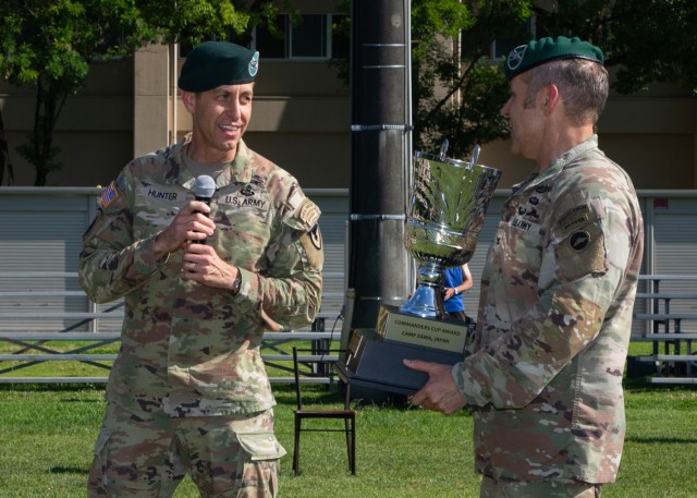 Col. Marcus Hunter, left, commander of U.S. Army Garrison Japan, accepts the Commander's Cup trophy from Col. Terry A. Butcher, deputy commander of U.S. Army Japan, during an awards ceremony at Camp Zama, Japan, June 12, 2024. The garrison team won the trophy for the third year in a row for its consistent performance in 25 different fitness and sports events. 