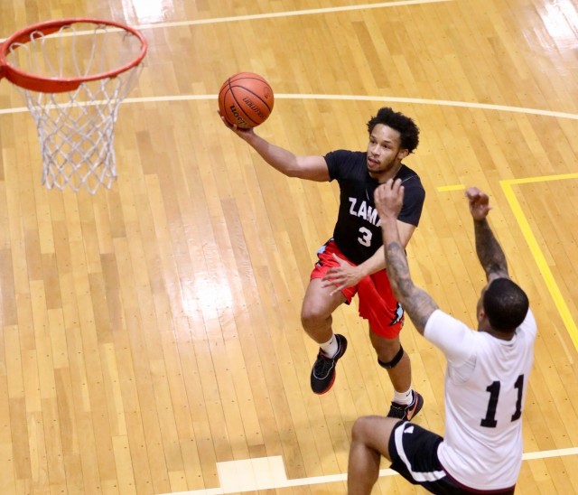 Juwan Russell, a member of the U.S. Army Garrison Japan team, goes in for a layup against a defender during a basketball tournament at Yano Fitness Center as part of the Commander’s Cup program at Camp Zama, Japan, Feb. 27, 2024. USAG Japan recently won the yearlong program for the third year in a row.