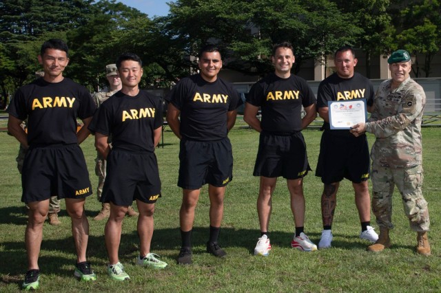 Col. Terry A. Butcher, right, deputy commander of U.S. Army Japan, presents a certificate of excellence to 38th Air Defense Artillery Brigade Soldiers who won the tug-of-war event during an Army Week awards ceremony at Camp Zama, Japan, June 12, 2024. Personnel across USARJ celebrated the Army’s 249th birthday with some friendly competition in various sports activities.