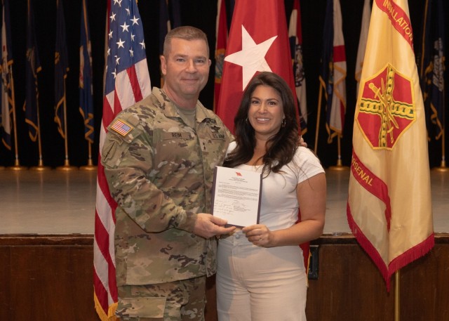 Maj. Gen. John T. Reim, Picatinny Arsenal Commanding General and Joint Program Executive Officer Armaments and Ammunition, presents a star-note congratulatory letter to Olivia Forsgren for her role in planning and executing the installation’s Month of the Military Child observance.  