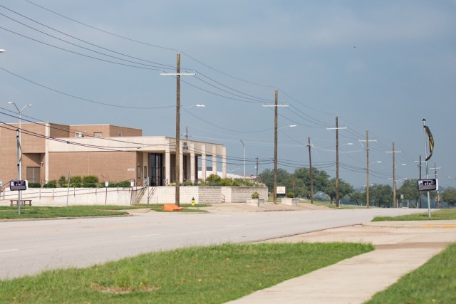 A row of electric poles stand on the left side of a street. 