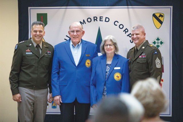 Three men and a woman standing pose for a picture. 