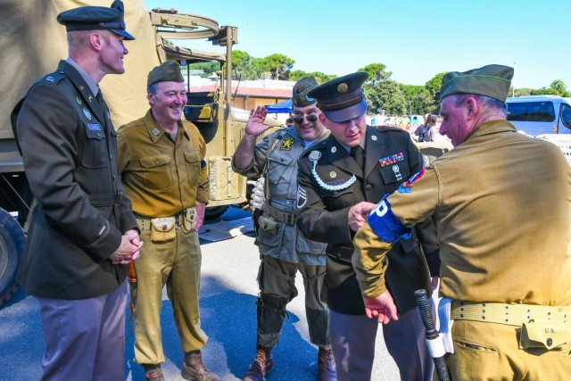 U.S. Army Soldiers and Italian World War II reenactors share stories at a July 11, 2024 event at Camp Darby commemoration the Nisei troops and the liberation of Livorno in World War II.