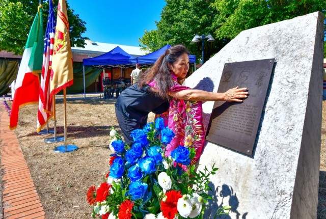 Valerie Matsunaga, a family members of the 442nd Regimental Combat Team, a segregated U.S. Army unit whose troops were of Japanese descent – known as Nisei – reaches out to the memorial for Pvt. Masato “Curley” Nakae, of Hawaii, who earned...