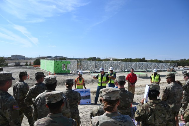 People look on at an unfinished structure.