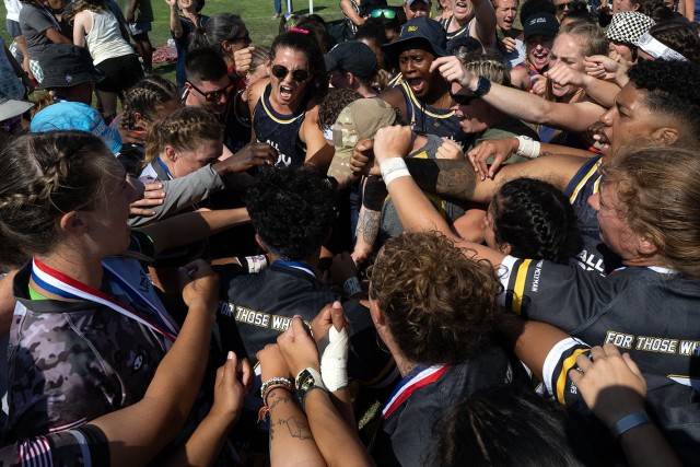Wearing a pink ribbon in her hair, Navy Ensign Megan Neyen  leads a huddle of rugby players from all services in a cheer  ‘For Those Who Can’t’ at the conclusion of the 2024 Armed Forces Women’s Rugby Championships in San Diego, Calif....