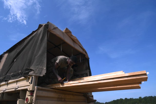 U.S. Army Pfc. Jermaine Highsmith, with the 1223rd Engineer Company, South Carolina Army National Guard, measures out wood beams to be cut to size during a construction project building fighting positions in a training area at Fort Jackson, S.C.,...