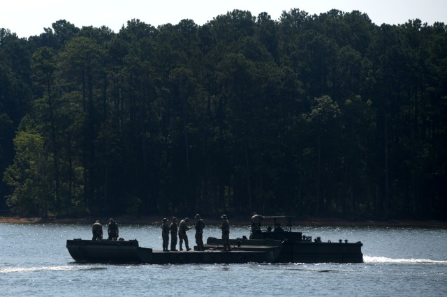 Soldiers with the 125th Multi-role Bridge Company, South Carolina Army National Guard, use an M30 Bridge Erection Boat to move an Improved Ribbon Bridge section during a training mission at Clarks Hill Training Site, S.C., July 17, 2024. During...