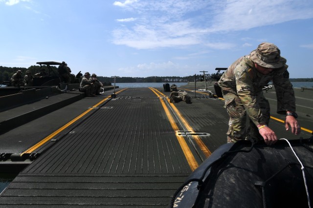 U.S. Army Staff Sgt. Christian Miller, a platoon sergeant with the 125th Multi-role Bridge Company, South Carolina Army National Guard, pulls a Combat Assault Craft small boat onto an Improved Ribbon Bridge section during a unit training mission...