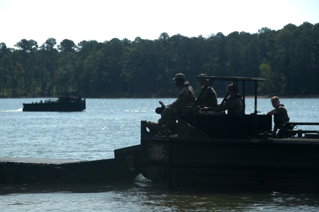 Soldiers with the 125th Multi-role Bridge Company, South Carolina Army National Guard, use an M30 Bridge Erection Boat to move an Improved Ribbon Bridge section during a training mission at Clarks Hill Training Site, S.C., July 17, 2024. During...