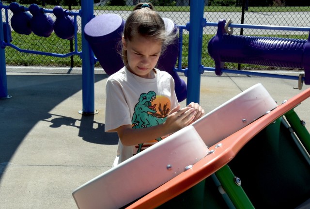 Jade Smith, 10, daughter of Sgt. 1st. Class Kyle Smith, Recruiting and Retention College instructor, plays on an interactive game at the new inclusive playground on Fort Knox, Kentucky, July 18 (U.S. Army photo by Shannon Collins)