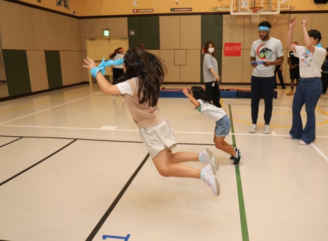 Residents of the Sagamihara Minami Children’s Home participate in the long jump competition during a mini-Olympics event at the Youth Center at Camp Zama, Japan, July 24, 2024. The event had six sporting activities and a medal ceremony inside...