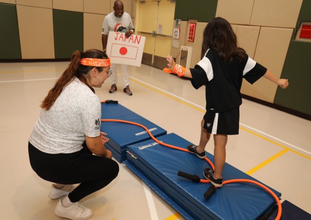 A resident of the Sagamihara Minami Children’s Home tries her luck in the high beam competition during a mini-Olympics event at the Youth Center at Camp Zama, Japan, July 24, 2024. The event had six sporting activities and a medal ceremony...