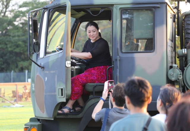 A visitor poses for a photo inside a light medium tactical vehicle during an Independence Day celebration at Camp Zama, Japan, June 29, 2024. The open-post event had plenty of food and entertainment including military static displays, children’s...