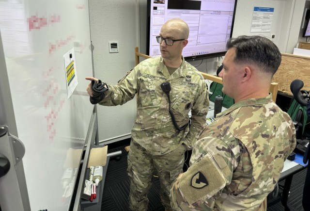 From left, Maj. Michael Clark and Sgt. 1st Class Jimmie Gilchrist, both assigned to U.S. Army Garrison Japan’s Directorate of Plans, Training, Mobilization and Security, work in the garrison’s Emergency Operations Center July 2, 2024, during...