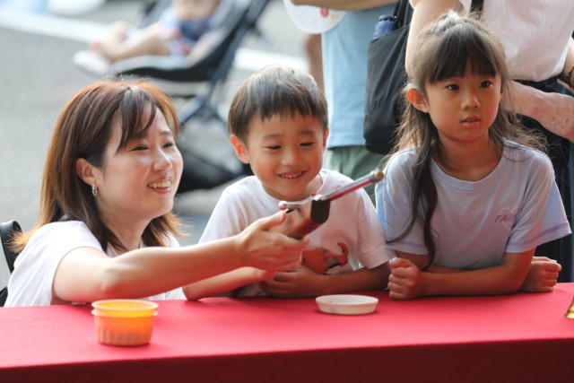 A family enjoys one of the children's games offered during an Independence Day celebration at Camp Zama, Japan, June 29, 2024. More than 16,000 people attended the daylong event that had plenty of food and entertainment including children’s...