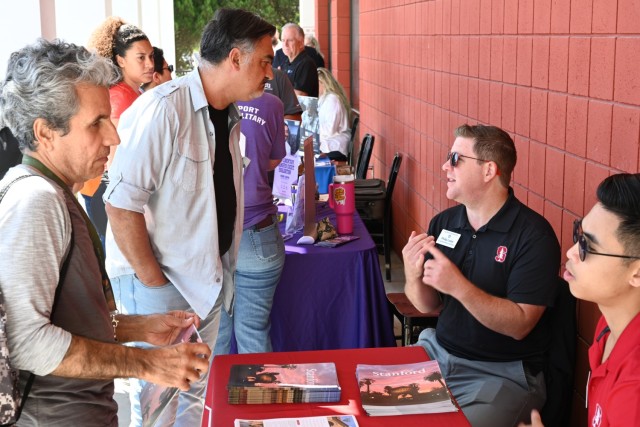 Representatives from Stanford University (right) speak to participants at the Presidio of Monterey college fair at Aiso Library, Presidio of Monterey, Calif., July 25.