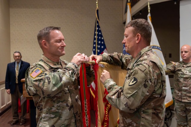 REDSTONE ARSENAL, ALABAMA - In one of his last acts as Redstone Arsenal Garrison Commander, Col. Brian Cozine and Command Sgt. Maj. Dylan Lemasters affix a streamer to the Garrison’s colors. The Garrison earned the Army Superior Unit Award for...