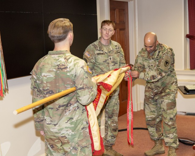 FORT BELVOIR, VIRGINIA - Fort Belvoir Garrison Commander Col. David Stewart and Headquarters Battalion Command Sgt. Maj. Daniel Hopkins attach the Army Superior Unit Award streamer to the Installation Management Command flag during a Command...