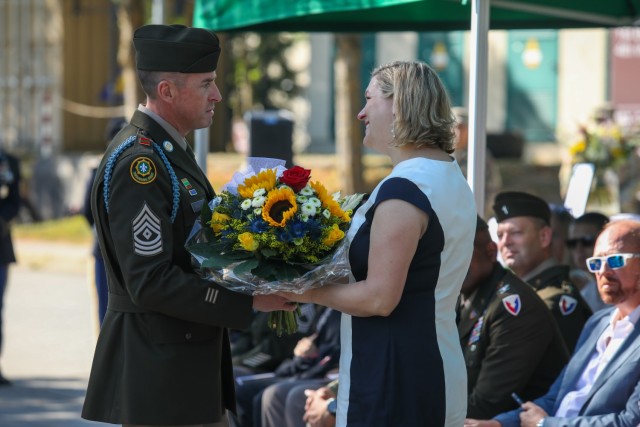 USAG BAVARIA - HOHENFELS, Germany -- Master Sgt. Shaun T. Frank, Bravo Company (Blackfoot) first sergeant, presents Nickayla Myers-Garner, the Gold Star spouse of fallen warrior Capt. Mark A. Garner, a bouquet of flowers. U.S. Army Garrison...