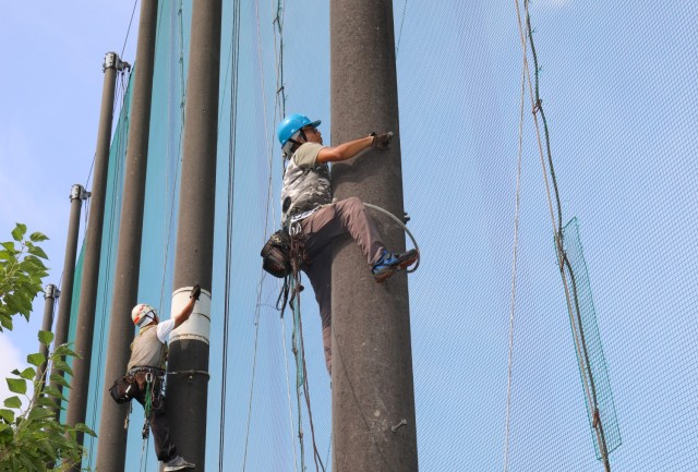 Contractors prepare to fix a net at the Camp Zama Golf Course's driving range in Japan Aug. 19, 2024. The course is currently undergoing extensive repairs to its mesh nets as part of an ongoing effort to keep balls inside the course area.