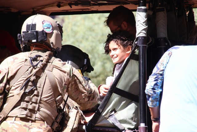 An Arizona Army National Guard Soldier helps a child into a UH-60 Black Hawk helicopter Aug. 24, 2024, at the Havasupai Indian Reservation. More than 100 people were evacuated out of the canyon after flood waters impacted the Havasupai community...