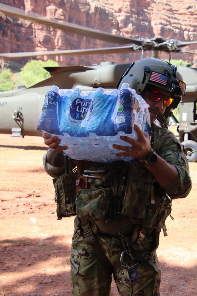 A U.S. Army Soldier of the Arizona National Guard (AZNG) unloads water from a UH-60 Blackhawk upon landing during one of three re-supply drop-offs providing water and food, August 24, 2024 on the Havasupai Indian Reservation. ...