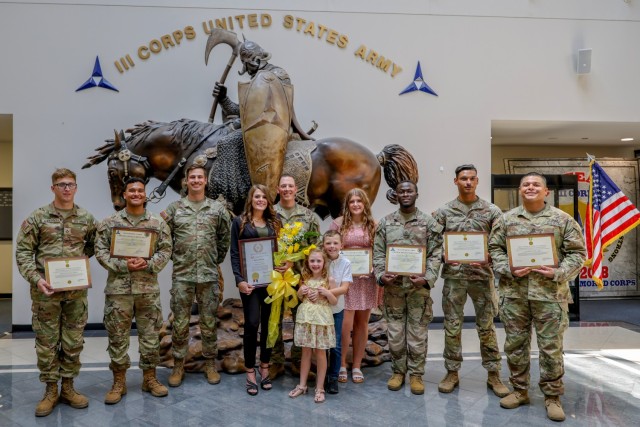 A group of people standing smile and pose for a photo.