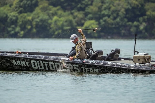 Army Outdoor Team member Master Sgt. John Branch works to bring his catch into the Army Bass Boat at the National Professional Fishing Leage Tournament, held in Tennessee, July 7-12,