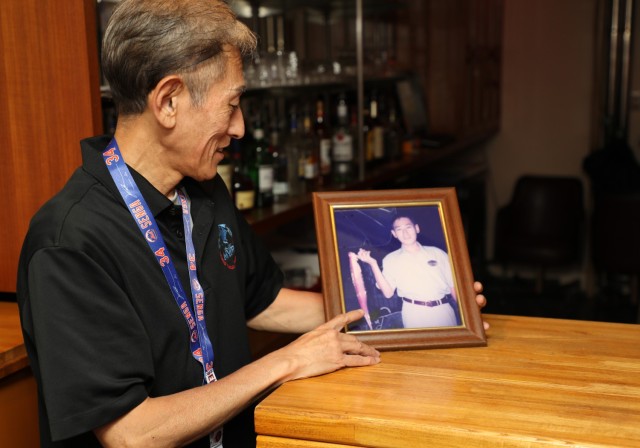 Takeshi Kusunoki, a bartender at the Kure Harbor Club, looks at a photo of himself around the time he first became an employee at Kure Pier 6, Japan, Sept. 5, 2024. Takeshi, who has worked at the club for 27 years, has been a familiar face for...