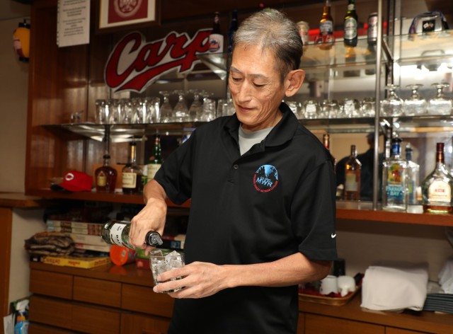 Takeshi Kusunoki, a bartender at the Kure Harbor Club, makes a drink inside the club's bar area at Kure Pier 6, Japan, Sept. 5, 2024. Takeshi, who has worked at the club for 27 years, has been a familiar face for customers who go there for a...
