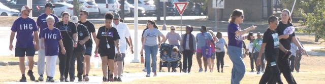 People walk on a paved sidewalk.