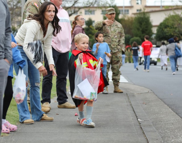 A child waits for candy to be tossed by participants in a homecoming parade at Camp Zama, Japan, Oct. 10, 2024. Several U.S. Army Garrison Japan personnel helped with the parade and a bonfire that night in support of Zama Middle High School students.