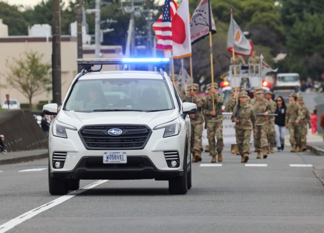 A U.S. Army Garrison Japan military police vehicle leads a homecoming parade across Camp Zama, Japan, Oct. 10, 2024. Several garrison personnel helped with the parade and a bonfire that night in support of Zama Middle High School students.
