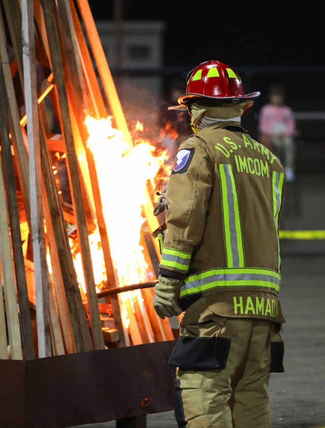A U.S. Army Garrison Japan firefighter lights a bonfire as part of Zama Middle High School's homecoming activities at Camp Zama, Japan, Oct. 10, 2024.