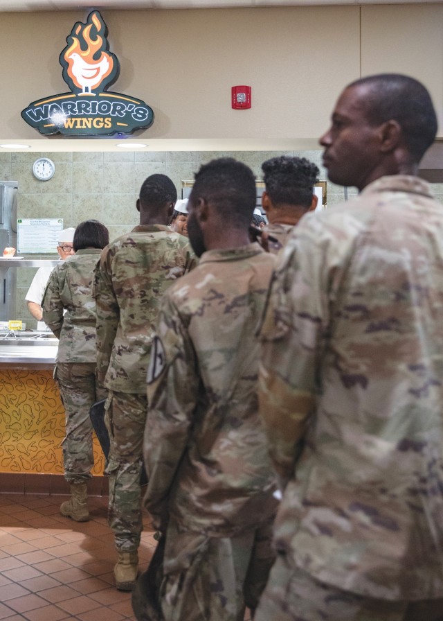 Soldiers line up at the "Warrior's Wings" station at the Headquarters Department of the Army Go for Green Action Station to receive their lunch Oct. 9 at the Operation Iraqi Freedom Dining Facility at Fort Cavazos