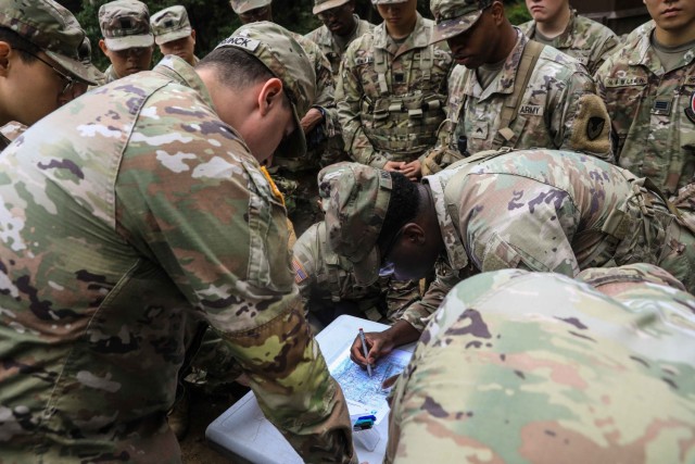 U.S. Army Pfc. Bryson Walker, assigned to Headquarters & Headquarters Company, Camp Casey Garrison, plots points on a map during land navigation training at Camp Casey, Oct. 15, 2024. Land Navigation training is essential for developing critical...