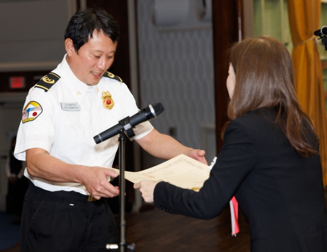 Hiroyuki Saito, left, a fire inspector at the Directorate of Emergency Services, receives a certificate from Rie Suetomi, director of the South Kanto Defense Bureau, during a length-of-service ceremony at Camp Zama, Japan, Oct. 29, 2024. The...
