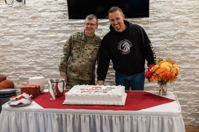 USAG Wiesbaden Commander Col. Troy Danderson and Christian Kaesemann, owner of The Italian Grill, cut the cake during the restaurant's official grand opening at The Airlift on Clay Kaserne Nov. 7, 2024. (Wiesbaden FMWR Photo by Travis Thurston)