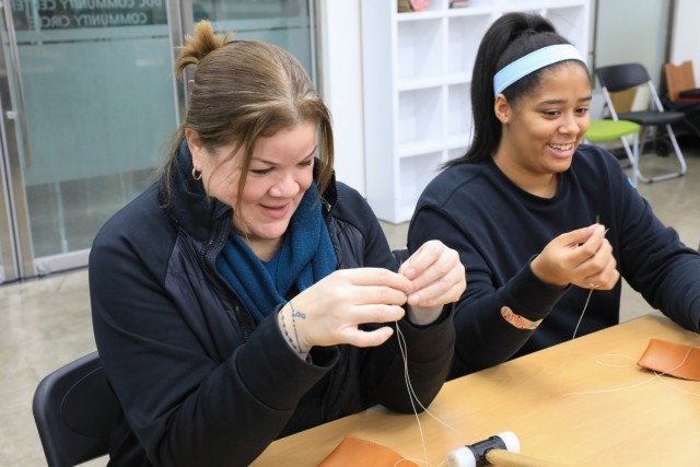 Peggy Galindo, U.S. Army Garrison Yongsan-Casey Internal Review chief, left, and Marissa Jordan, U.S. Army Garrison Yongsan-Casey Family Advocacy Program Victim Advocate, saddle stitch their leather wallets during a Newcomers Cultural Awareness...