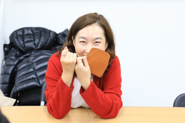 Kim, Song Ae, U.S. Army Garrison Yongsan-Casey community relations officer, showcases her saddle-stitched leather wallet during a Newcomers Cultural Awareness and Immersion Tour hosted by Dongducheon city, Bosan-dong Community Center, Bosan-dong,...