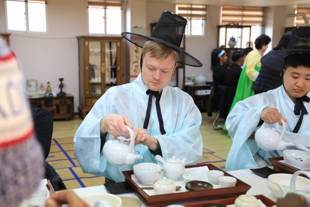 U.S. Army Staff Sgt. Jameson Harris, assigned to U.S. Army Garrison Yongsan-Casey, pours fresh tea the traditional way while wearing a hanbok during a Newcomers Cultural Awareness and Immersion Tour hosted by Dongducheon city, South Korea, Dec....