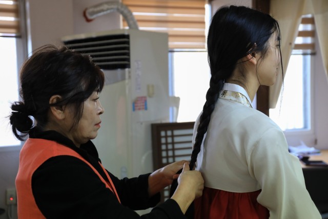 U.S. Army 2nd Lt. Victoria Nguyen, assigned to 1st Battalion, 38th Field Artillery Regiment, 210th Field Artillery Brigade, gets her hair braided while wearing a hanbok during a Newcomers Cultural Awareness and Immersion Tour hosted by Dongducheon...