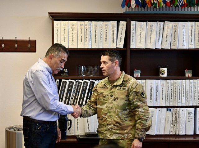 Col. Dan Artino, right, commander of U.S. Army Garrison Presidio of Monterey, congratulates Oscar Ordonez, U.S. Army Garrison Presidio of Monterey housing chief, on his retirement during a ceremony at Ord Military Community, Seaside, Calif., Dec. 13.