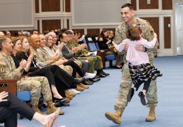 Command Sgt. Maj. David A. Rio hugs his daughter, Evelyn, during his change of responsibility ceremony at Camp Zama, Japan, Dec. 12, 2024. Command Sgt. Maj. Rick Meeker assumed responsibility of U.S. Army Garrison Japan's senior enlisted...