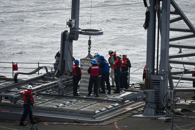 Sailors from Navy Cargo Handling Battalion One (NCHB-1) onboard USS Chosin (CG-65) work with ship’s force to complete a demonstration of the Transferrable Rearming Mechanism VLS Reloading At-Sea with the USNS Washington Chambers (T-AKE 11) on...