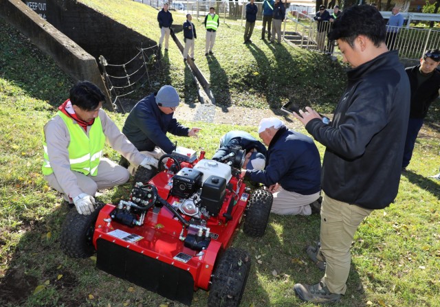 Directorate of Public Works employees take a closer look at a Sanyokiki remote-controlled lawnmower at Camp Zama, Japan, Dec. 6, 2024. DPW crews plan to use the mower to cut grass on the installation’s steep hills.