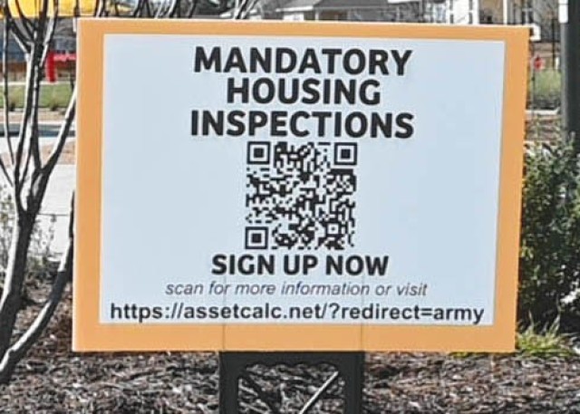 A sign sitting staked in the ground reads "MANDATORY HOUSING INSPECTIONS" with a QR code and a url underneath."